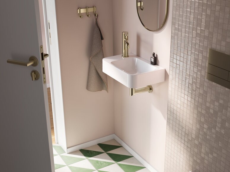 HEWI Fittings AQ Washbasin A rectangular washbasin with a tap and a siphon in the wash area, set against a beige wall with beige tiles