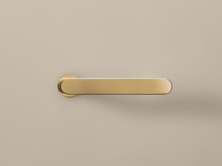 HEWI Range 270 PVD lever handle Matt gold-coloured PVD door handle with a round rose against a beige surface