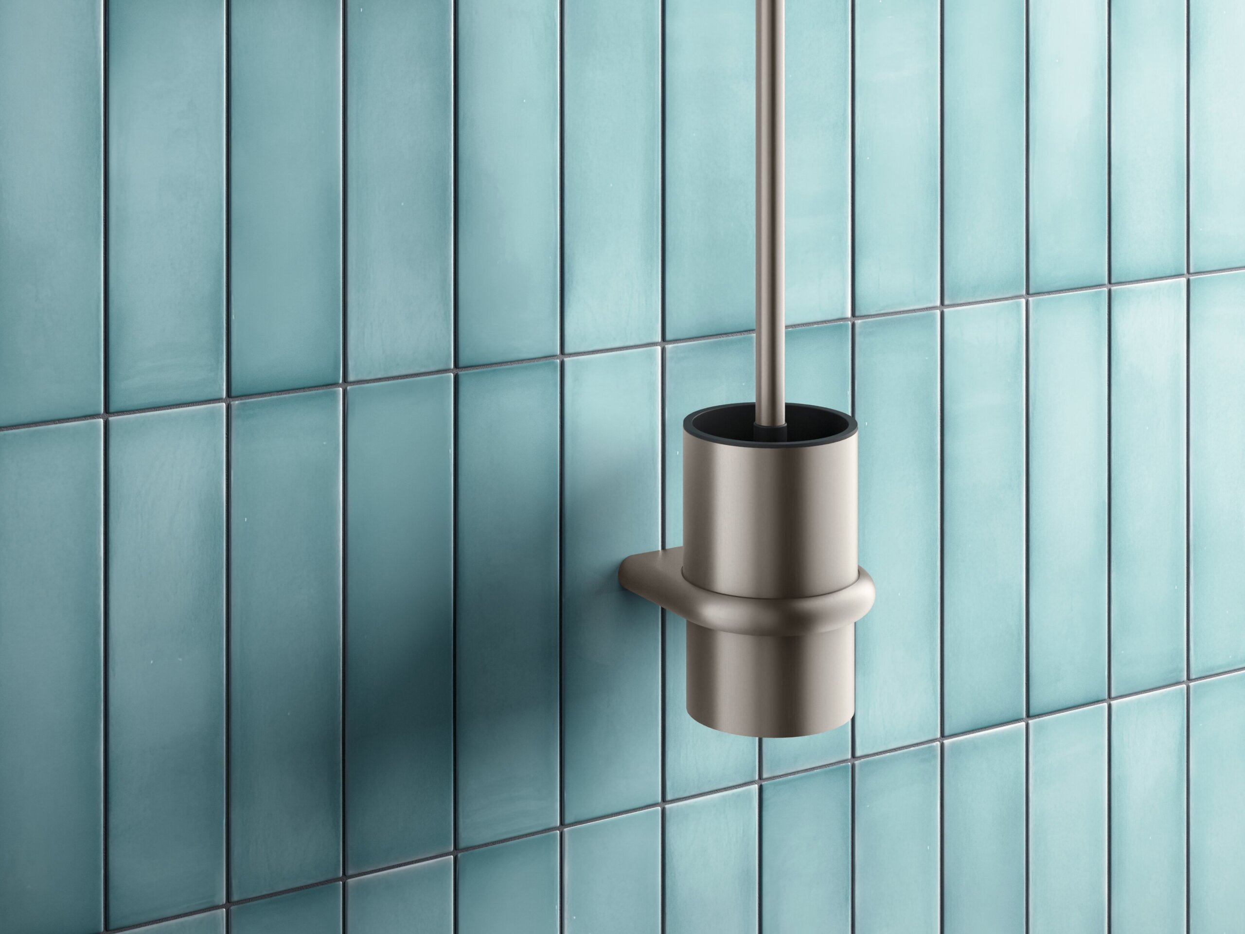 Toilet brush and side-mounted toilet roll holder with a bronze-coloured PVD coating against a backdrop of blue tiles