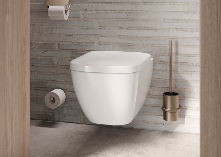 Wall-hung WC with a bronze-coloured PVD coating on the toilet brush, the toilet roll holder and the spare roll holder