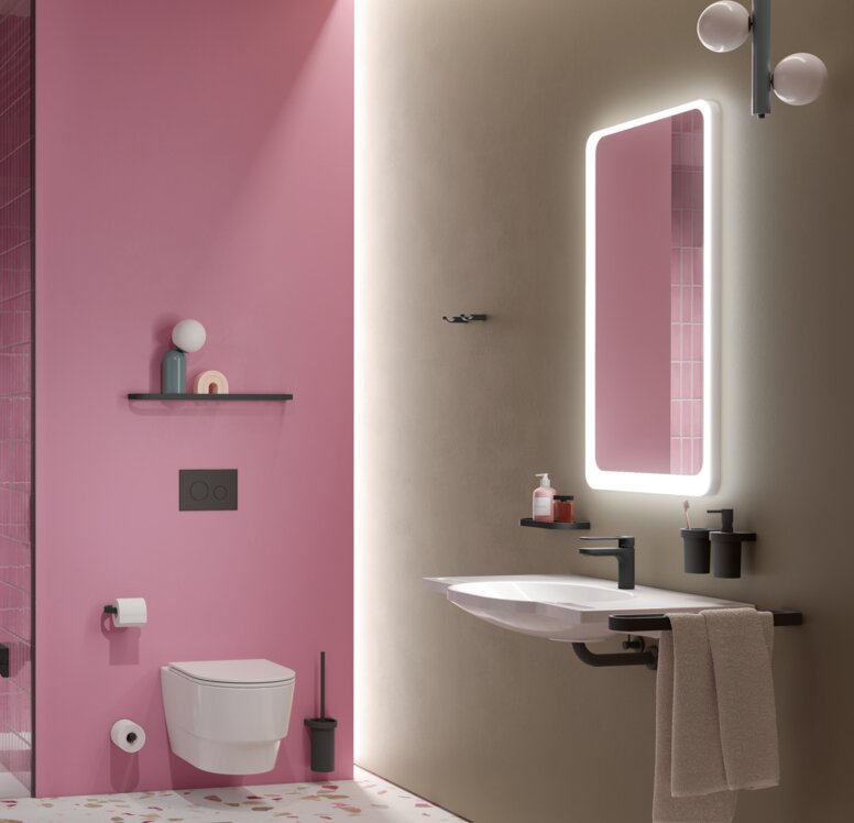 HEWI System 800 Interior A hinged seat next to the shower handrail in a shower cubicle with a stool and pink tiles, next to which is a WC and a washbasin with a mirror