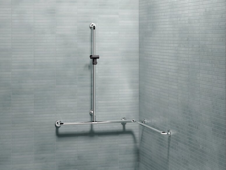 HEWI WARM TOUCH shower handrail with slidable rail with shower head holder L-shaped support rail with a vertical shower rail and shower head holder on a tiled wall in the shower area