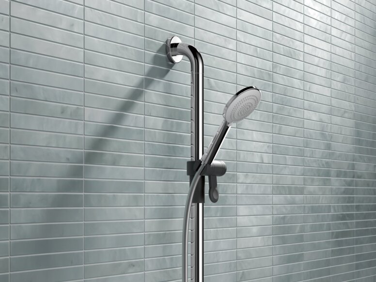 Chrome-plated shower handrail with an adjustable shower head holder, fitted to a light blue tiled wall