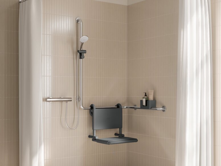 HEWI WARM TOUCH Interior Wall-mounted seat with backrest, fitted to an L-shaped shower rail on a beige-coloured tiled wall