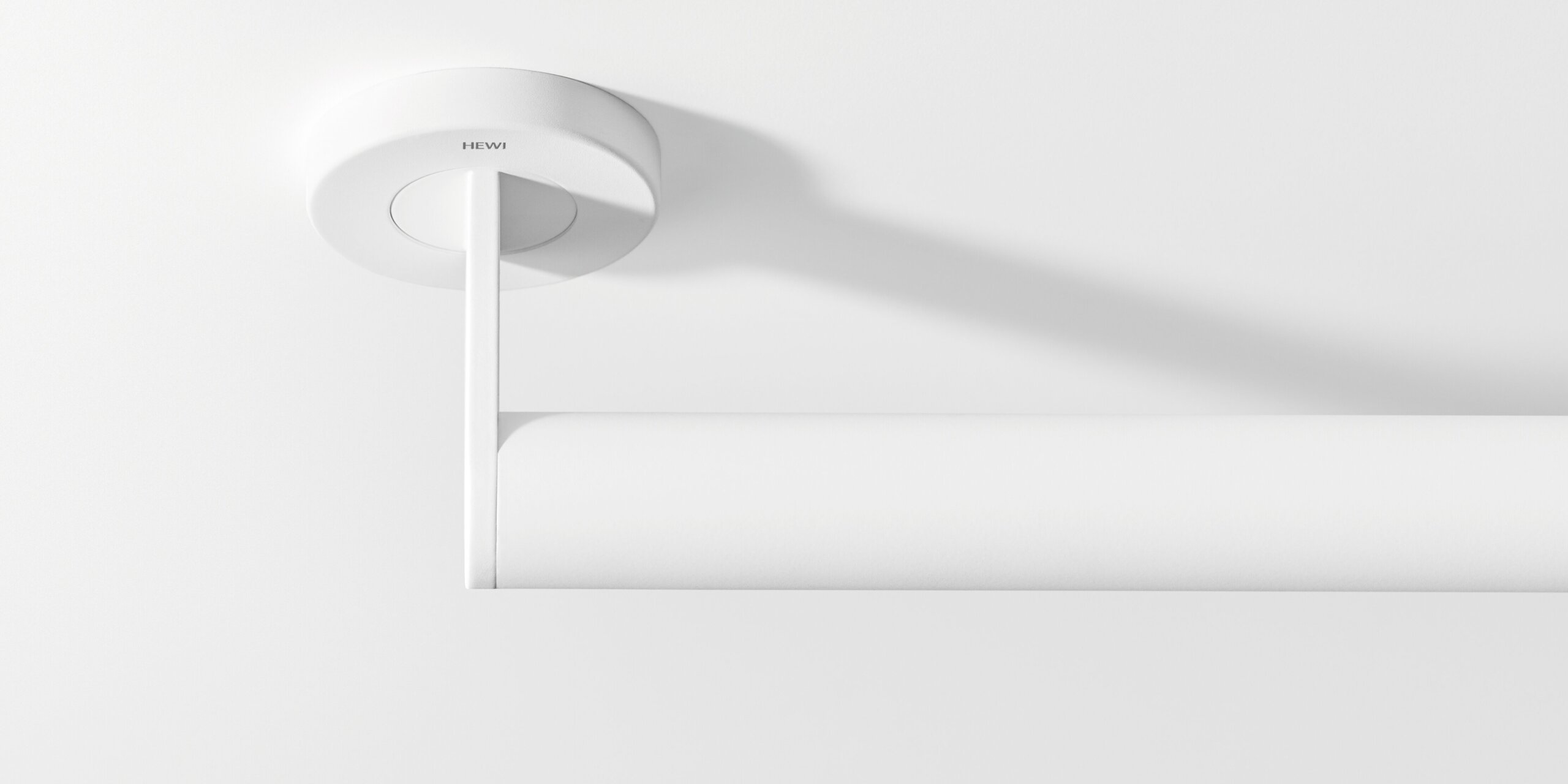 White support rail with a tubular grip and round wall mounting against a white background, viewed from above