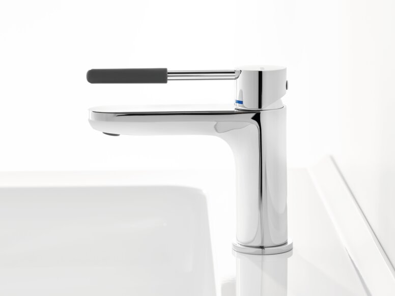 Chrome-plated tap with a long lever handle and dark grey grip sleeve on a white washbasin against a white background